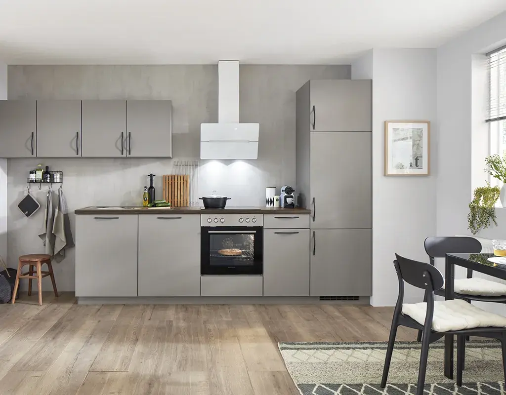 Zeitlose Einbauküche in Grau mit Backofen, Oberschränken und weißer Dunstabzugshaube. Praktische Küchenlösung mit viel Stauraum und funktionalem Design für moderne Haushalte.